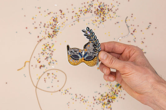 a mardi gras mask with beads and streamers