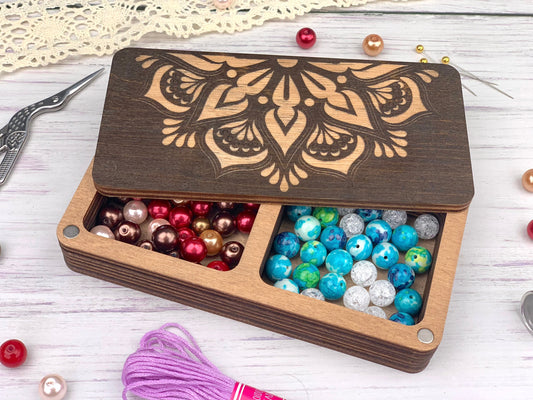 a wooden box filled with beads and a pair of scissors