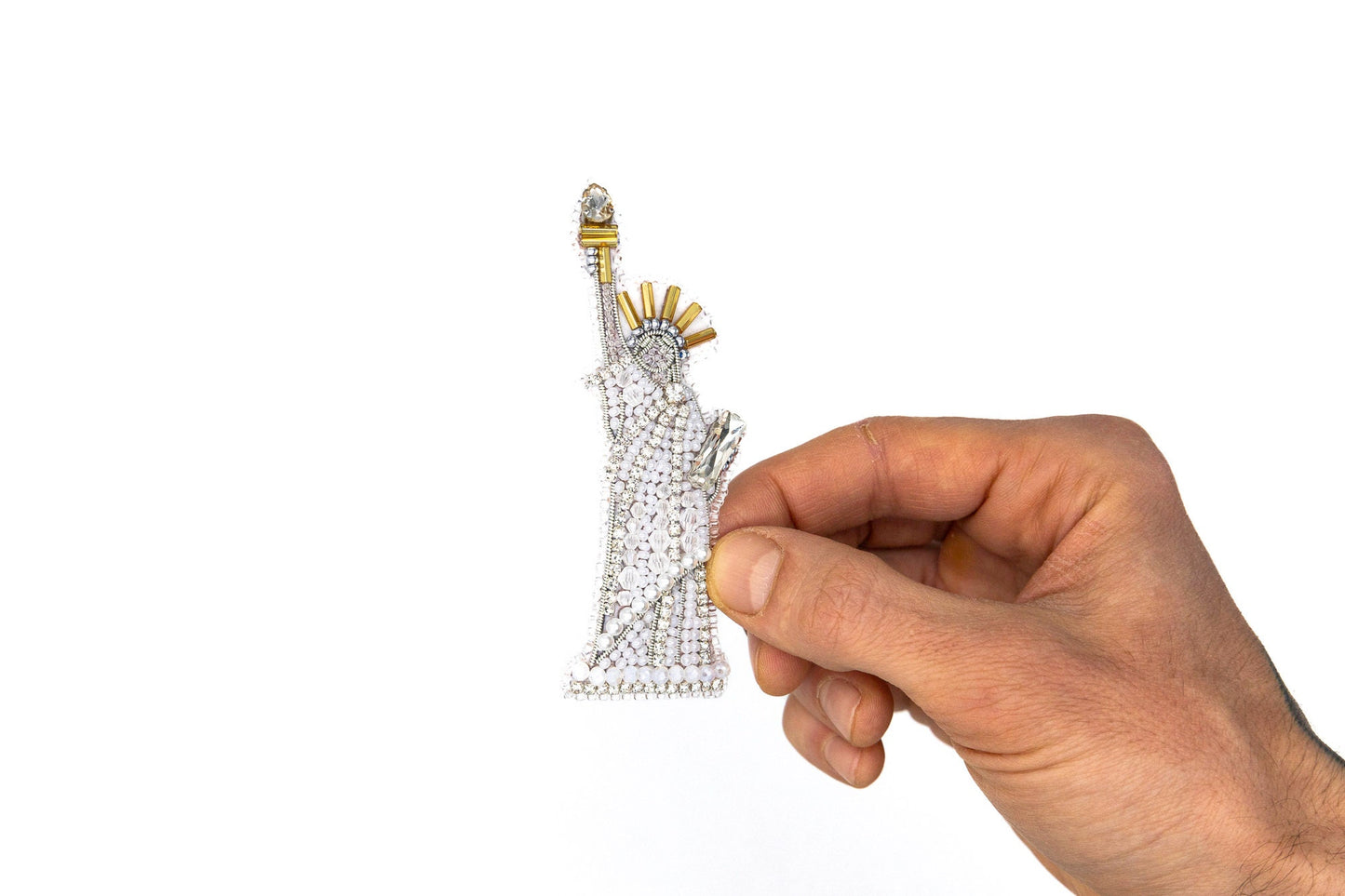 a hand holding a tiny statue of liberty