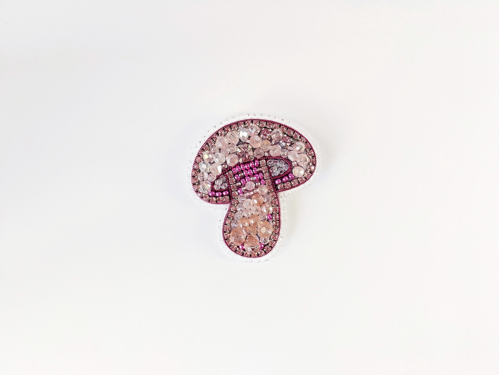 a brooch with a pink and white design on it