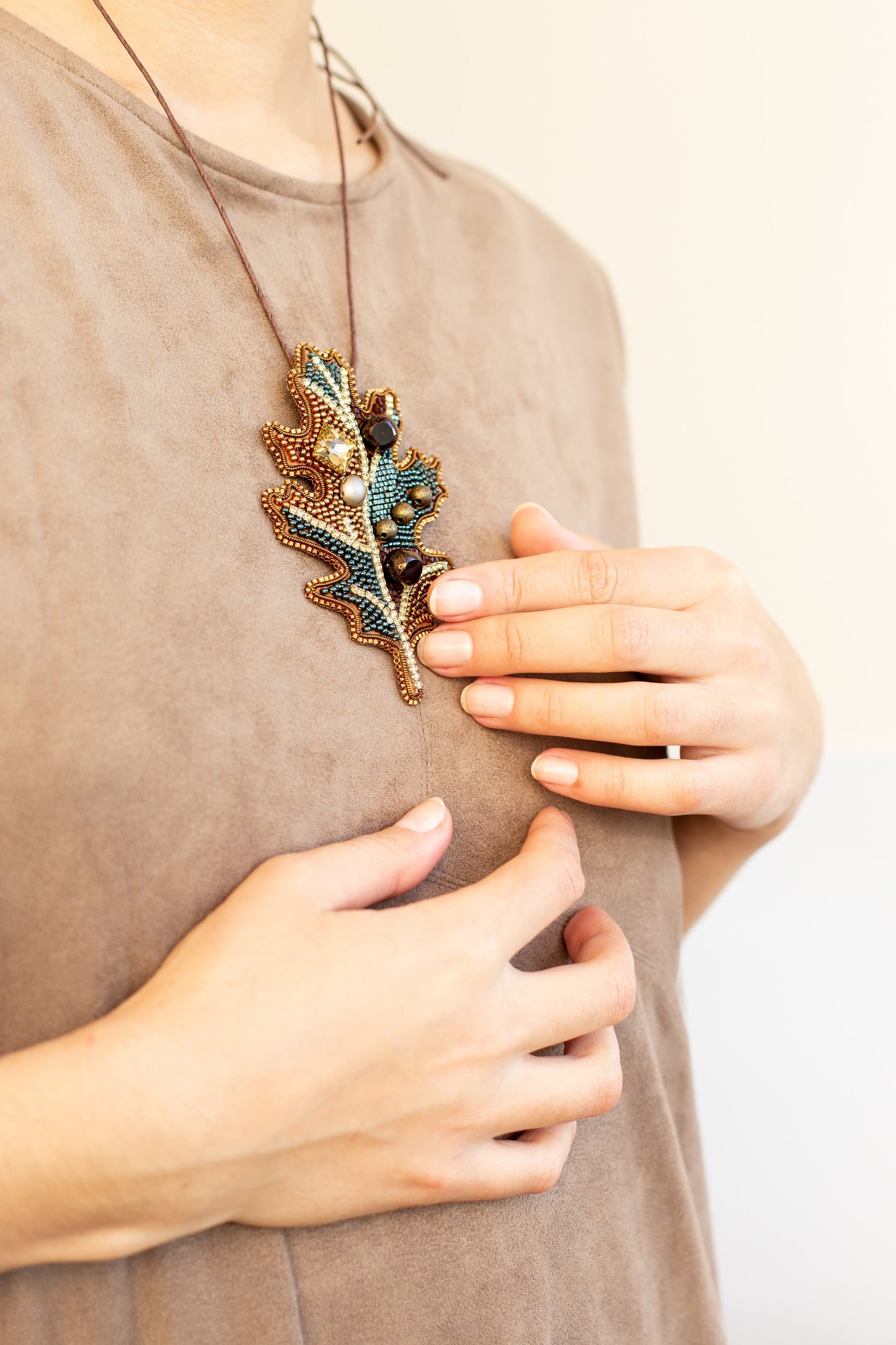 a woman wearing a necklace with leaves on it
