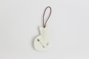 a white ornament hanging from a brown cord