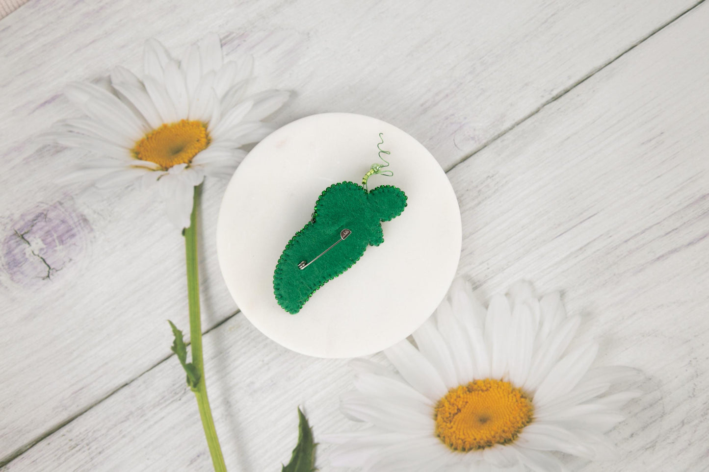 a white plate topped with a green piece of broccoli