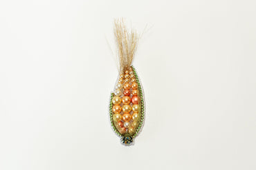 a beaded corn cob hanging on a wall