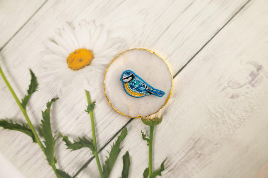 a blue bird sitting on top of a white flower