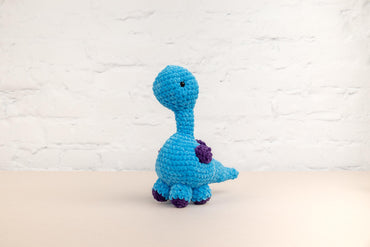 a crocheted blue toy sitting on top of a table