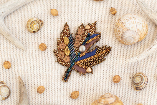 a picture of a brooch with a leaf on it