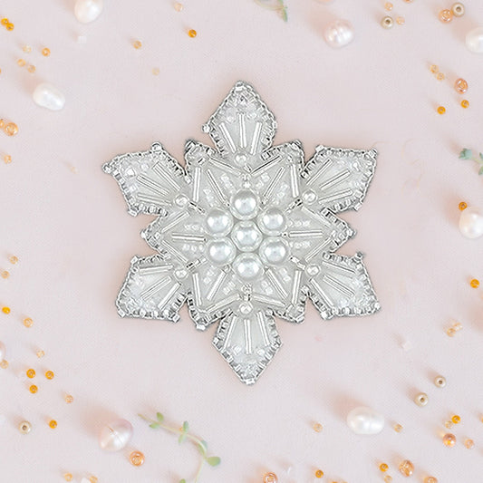 a white brooch with pearls on it