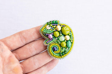 a close up of a person's hand holding a brooch