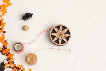 a table topped with beads and a wooden clock