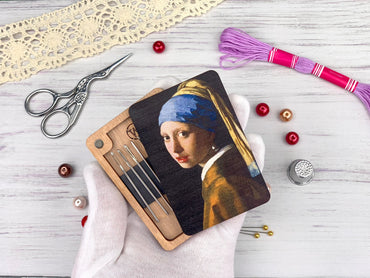 a girl with a pearl ear holding a picture of a girl with a pearl ear