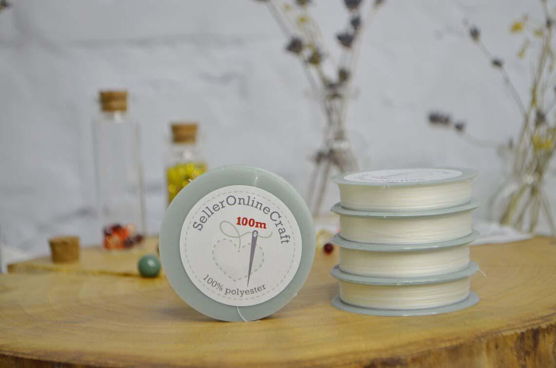 a stack of white spools of thread sitting on a wooden table