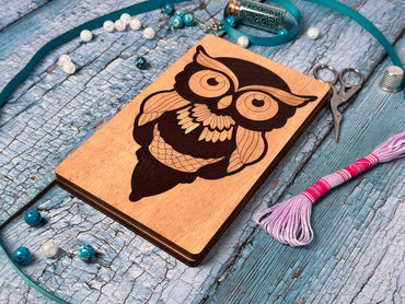 a wooden notebook with an owl on it