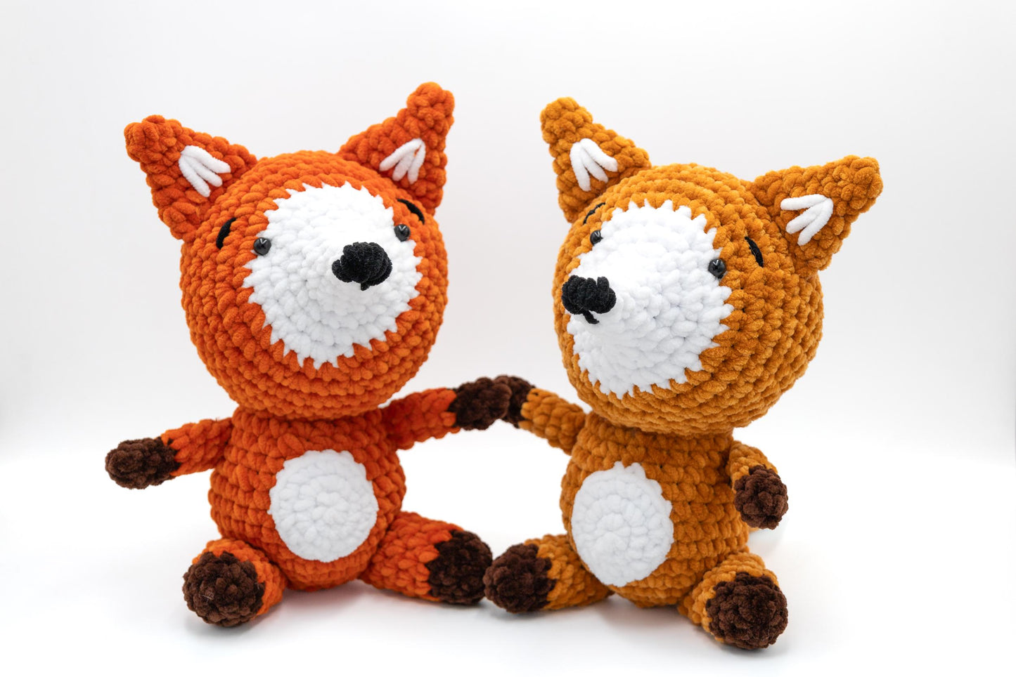 two crocheted stuffed animals sitting next to each other