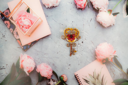 a key is surrounded by pink flowers on a table