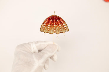 a hand in white gloves holding an umbrella