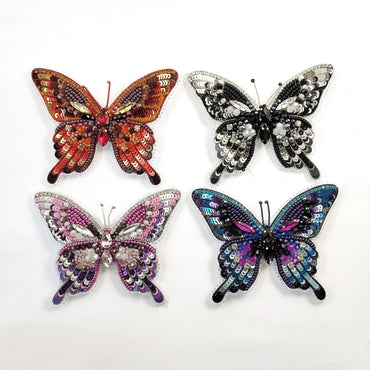 a group of three colorful butterflies sitting on top of a white surface