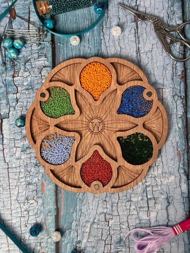 a wooden plate with a bunch of beads on it