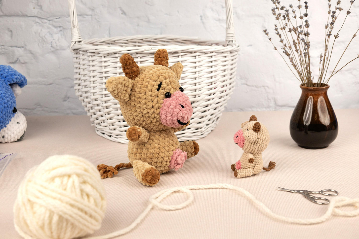 a stuffed animal sitting on top of a table next to a ball of yarn