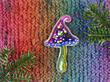a knitted christmas ornament hanging from a tree branch