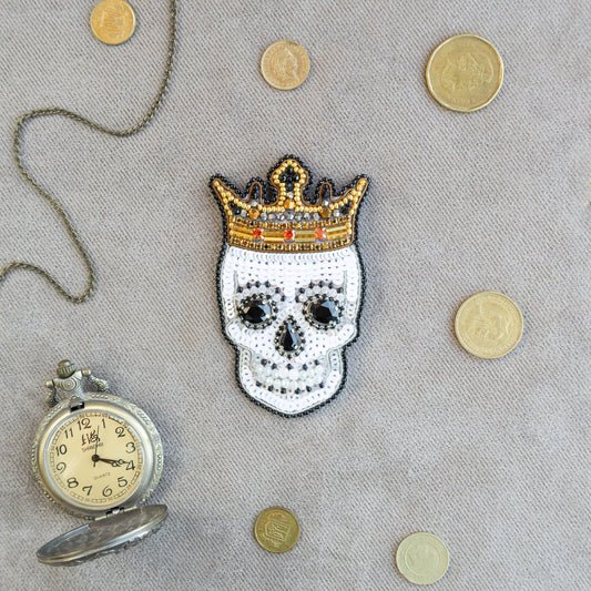 a skull with a crown next to a pocket watch