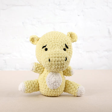 a small yellow stuffed animal sitting on a table