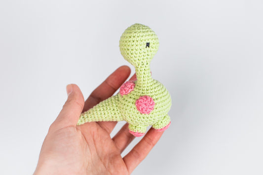 a hand holding a small crocheted stuffed animal