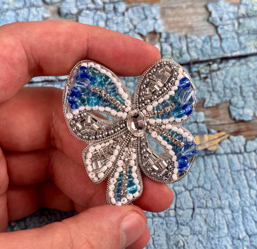 a person is holding a brooch in their hand