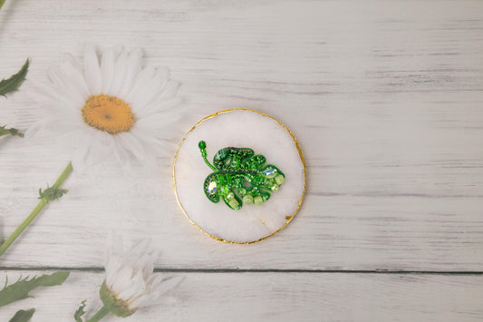 a plate with a green broccoli on it next to a flower