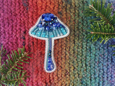 a knitted wall hanging with a blue lamp on it
