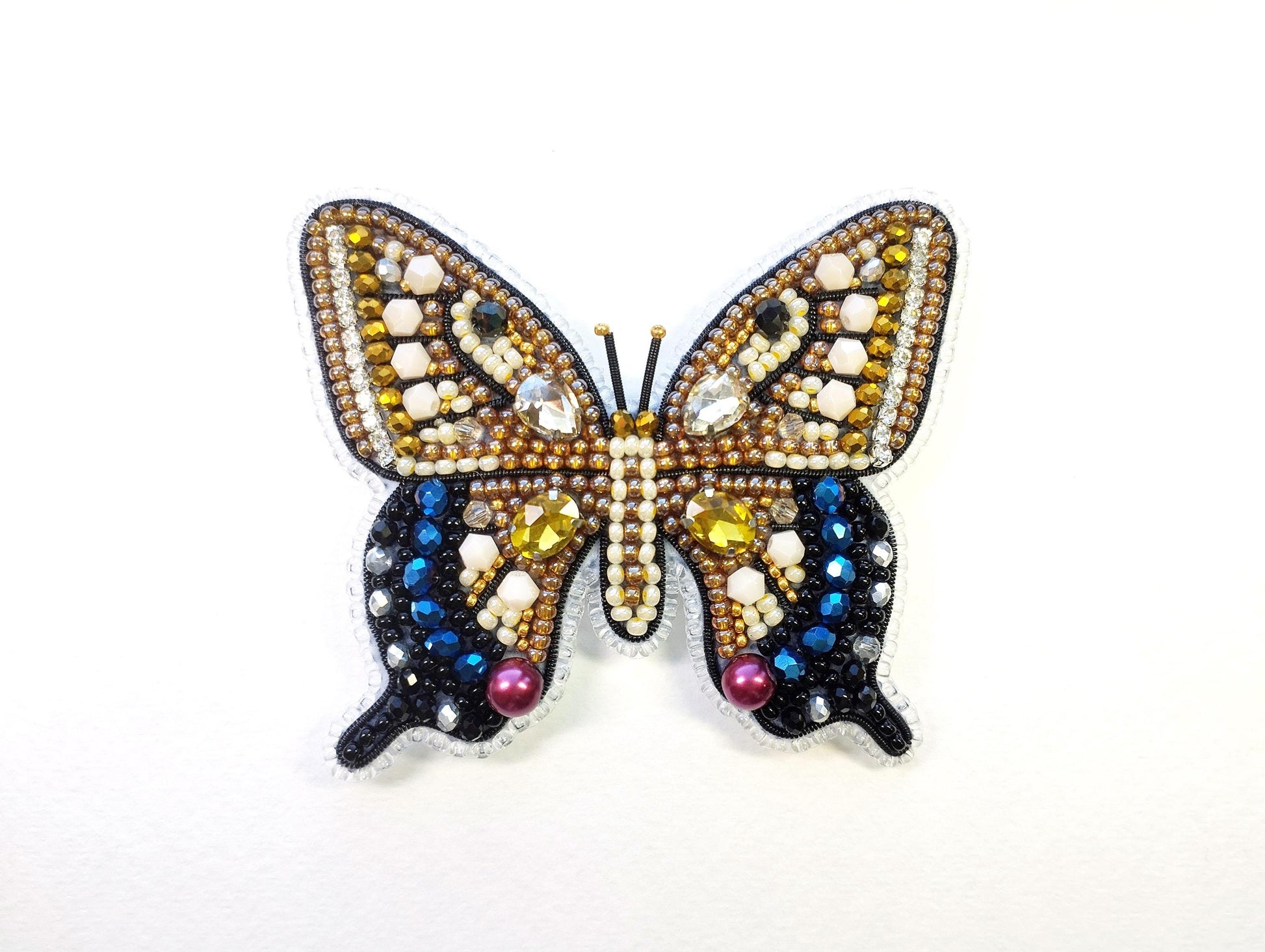 a butterfly brooch with multicolored beads