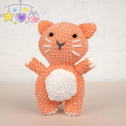 a crocheted cat sitting next to a ball of yarn