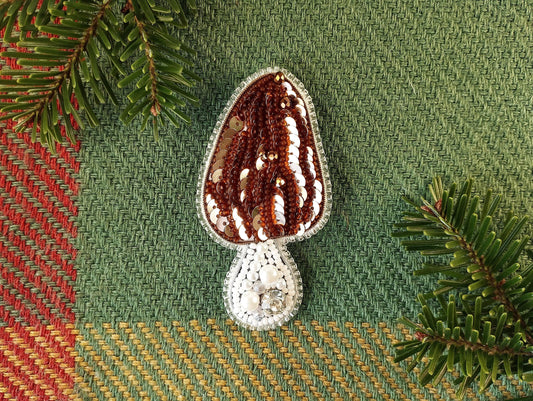 a crocheted object sitting on top of a table next to a pine tree