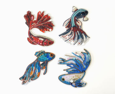 a group of three fish shaped magnets on a white surface