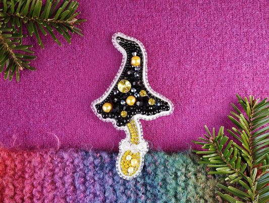 a knitted christmas tree ornament on a purple background