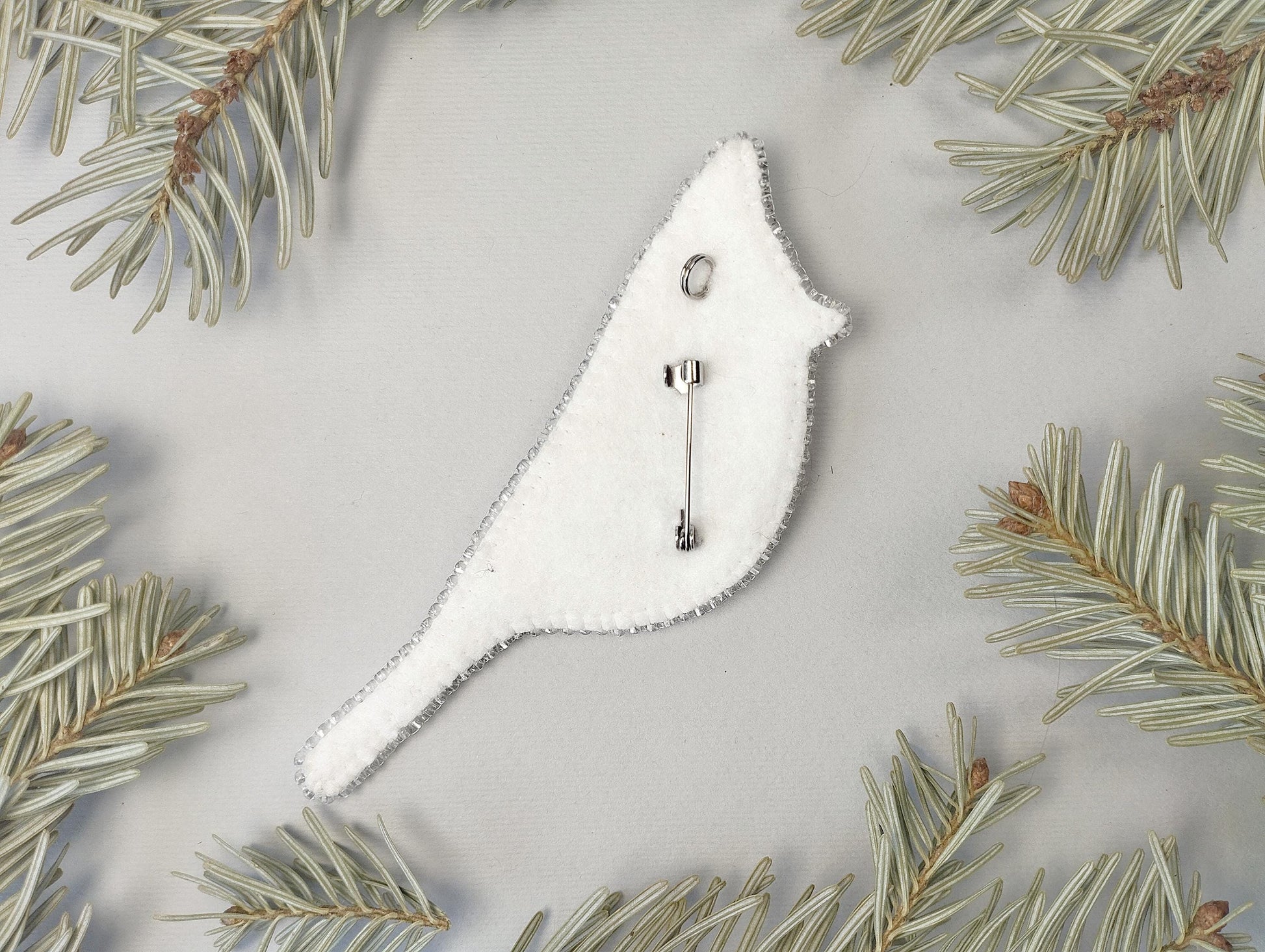 a christmas ornament hanging from a pine tree