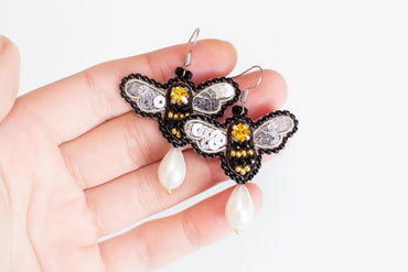 a person holding a pair of earrings in their hand