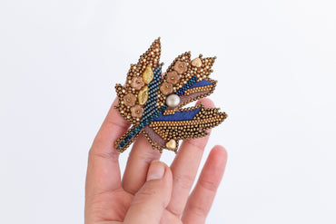 a person is holding a brooch in their hand