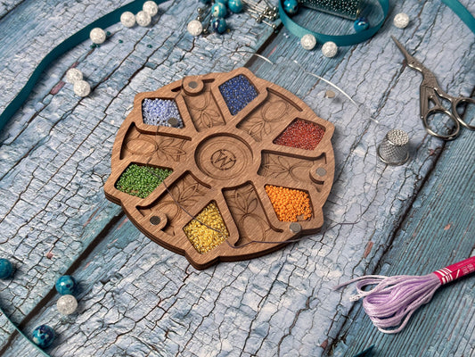 a wooden wheel with beads and a tassel on a table