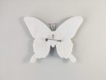 a white clock with a white butterfly on it