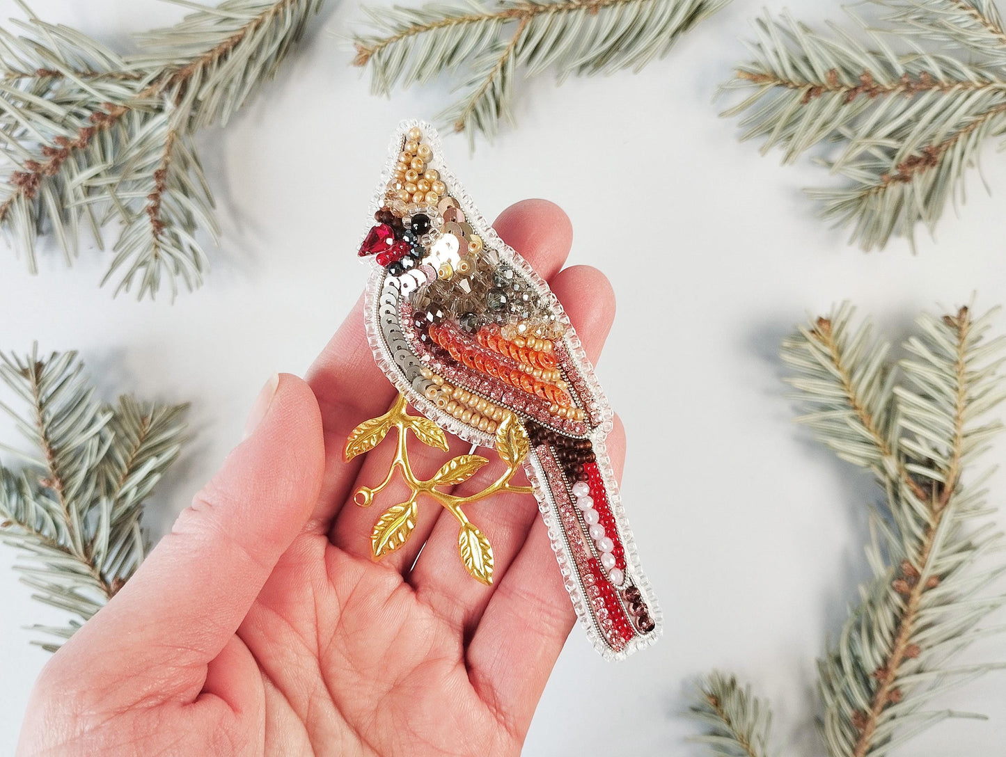 a person holding a bird brooch in their hand