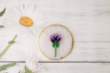 a white wooden table with a white flower and a gold frame