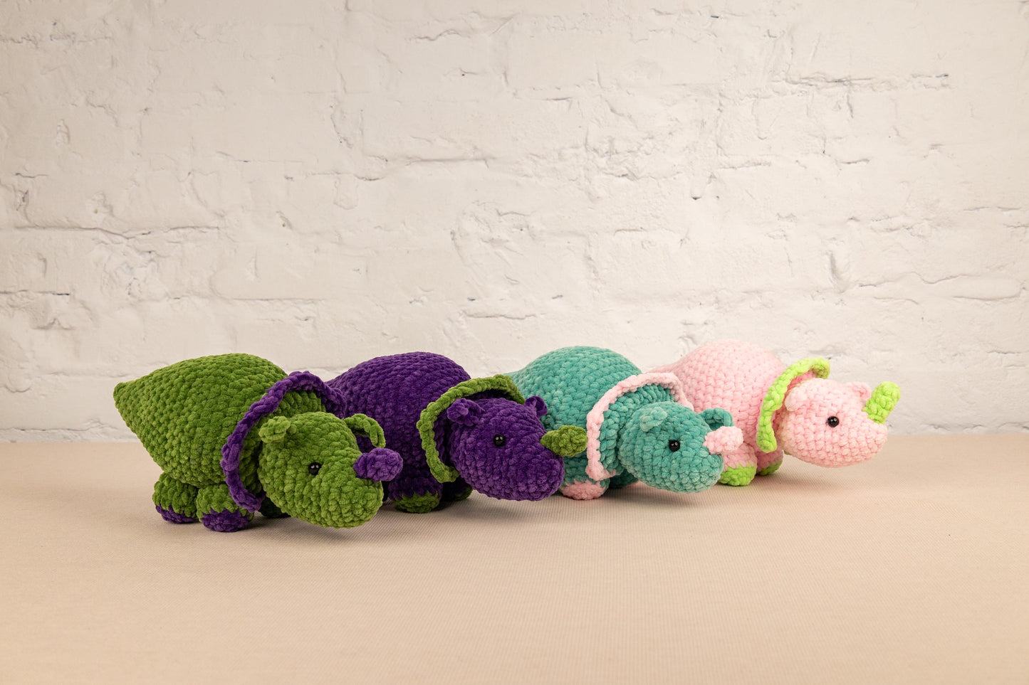 a row of crocheted stuffed animals sitting next to each other