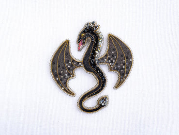 a brooch with a black dragon on it