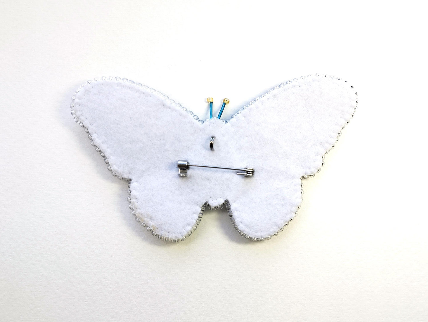 a clock made out of felt with a butterfly on it