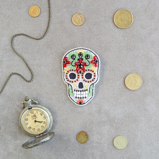 a clock and a beaded skull on a table
