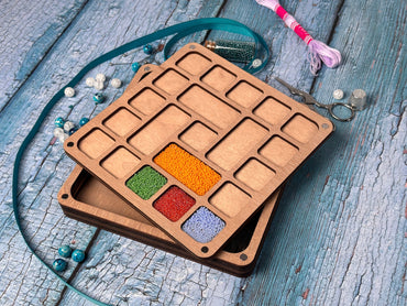 a wooden tray filled with different colored beads