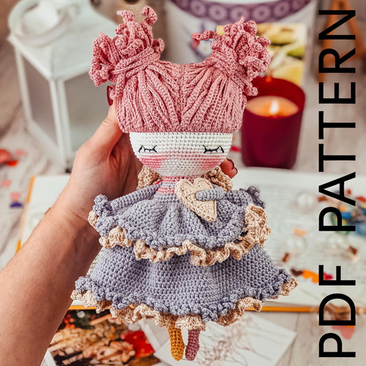 a hand holding a doll with a crocheted dress