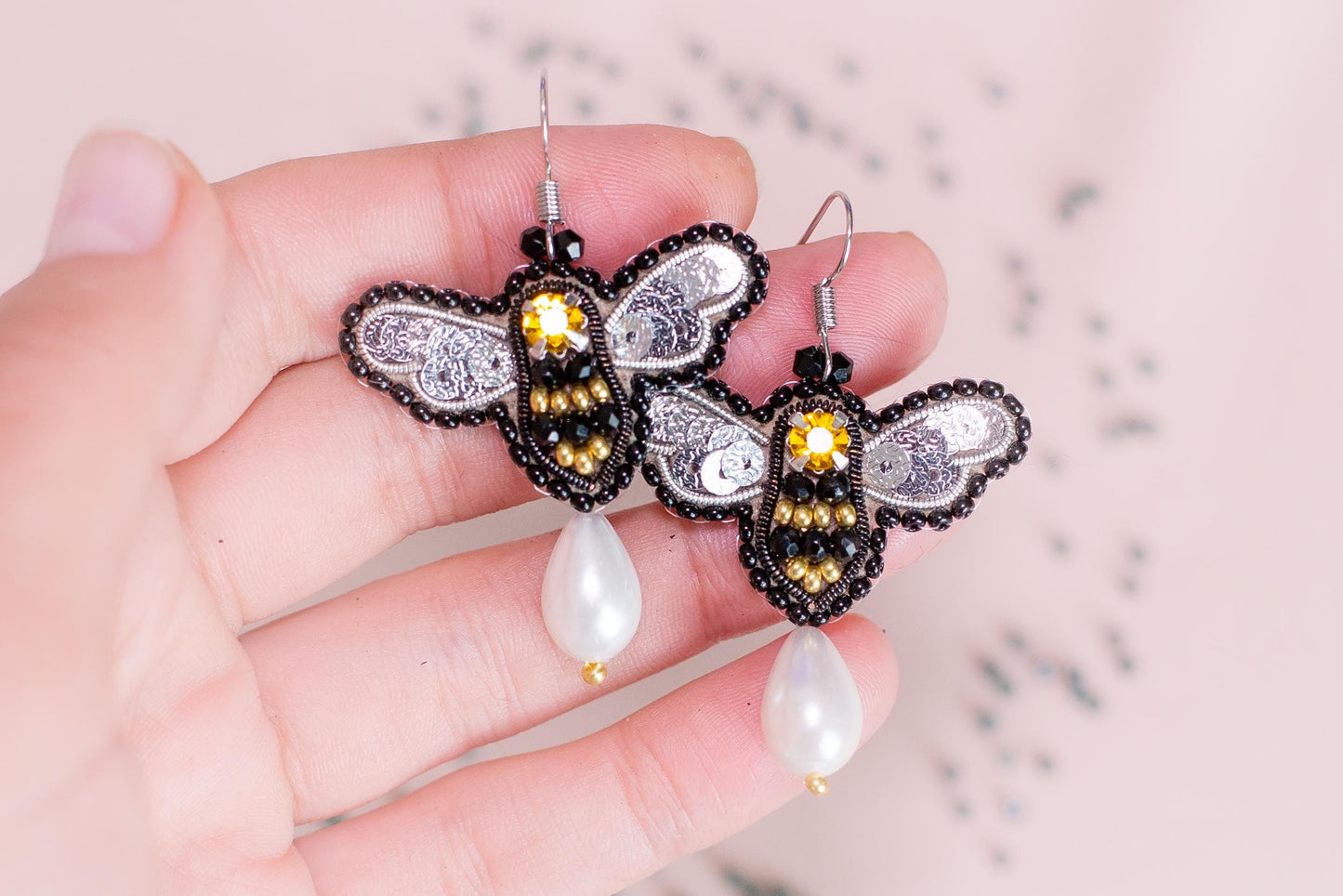 a person holding a pair of earrings in their hand