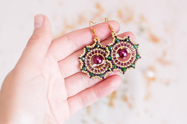 a person holding a pair of earrings in their hand